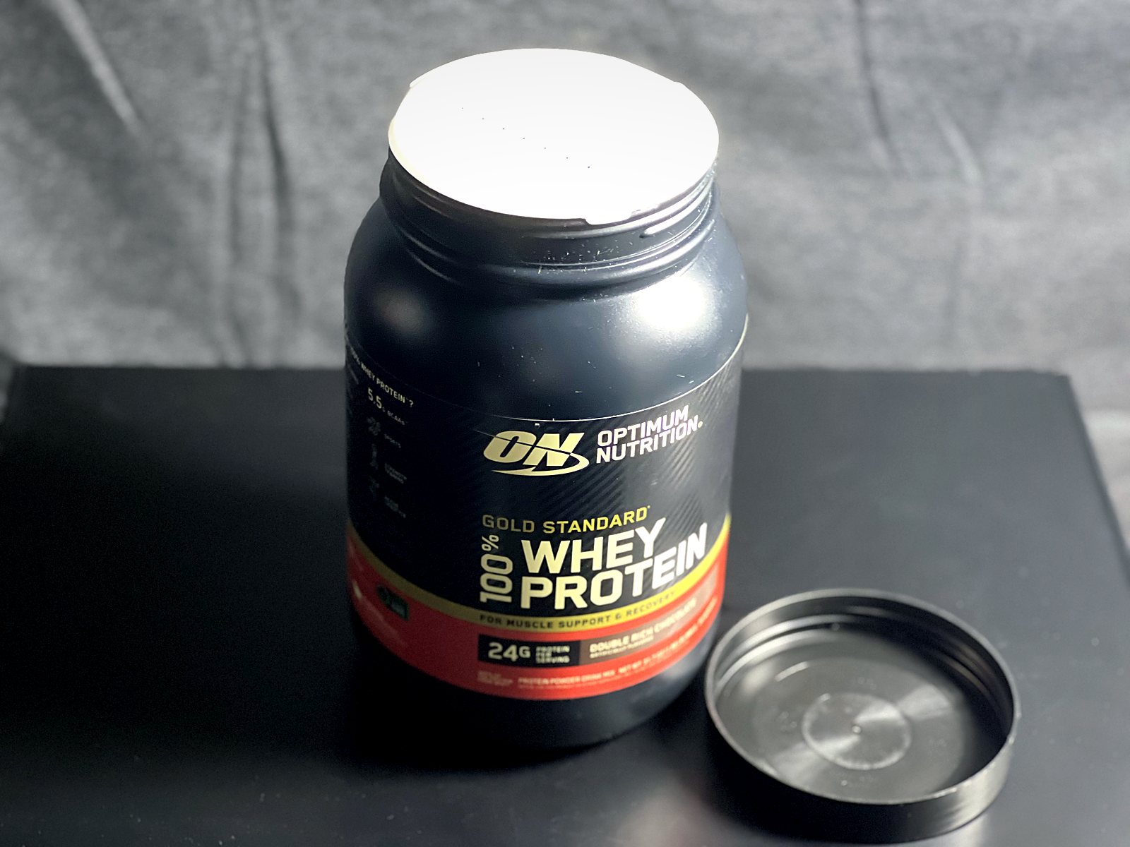 Gold Standard 100% Whey con la tapa abierta y el sello interno intacto